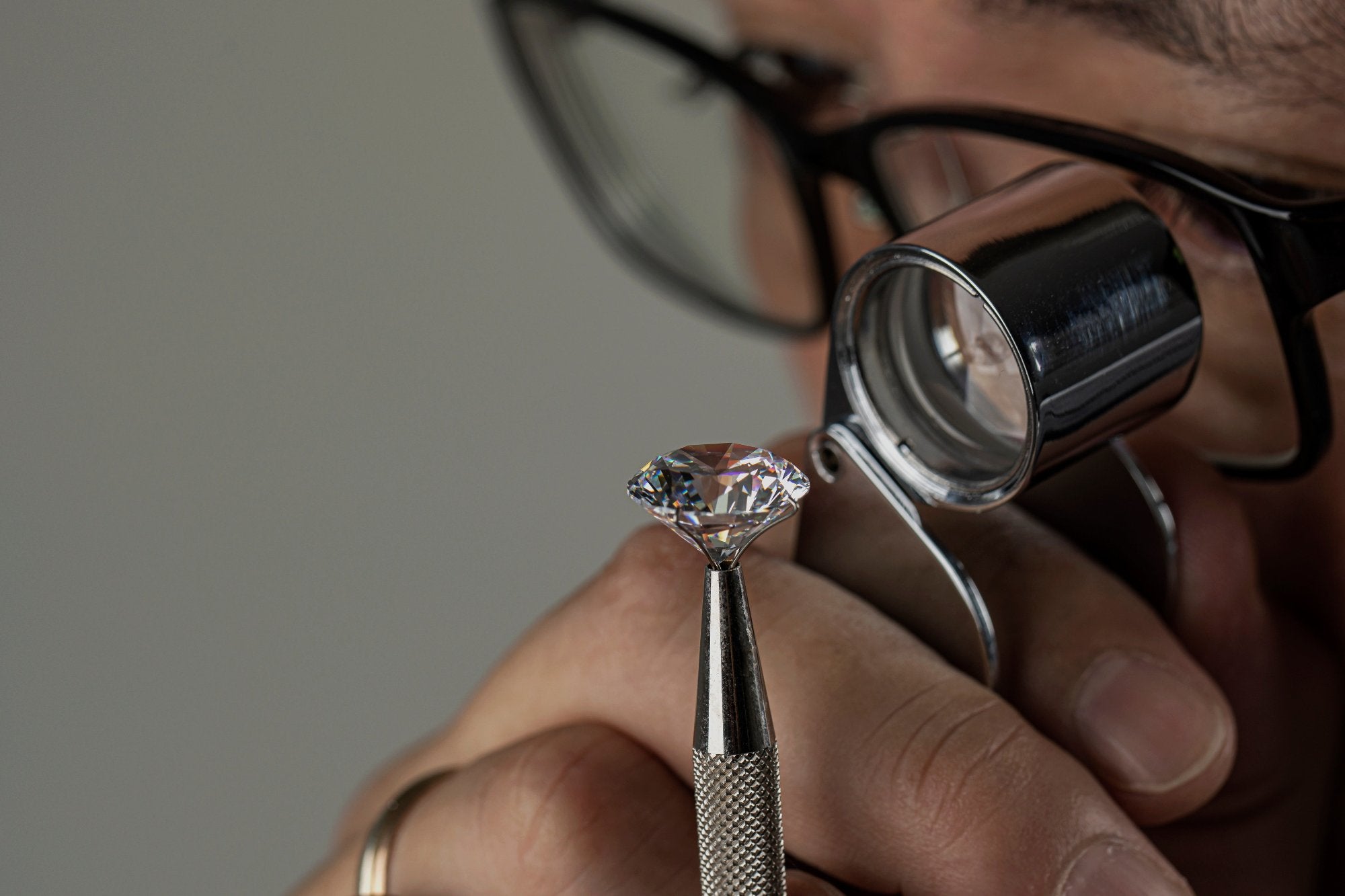 Ein Experte inspiziert einen makellosen Labordiamanten mit einer Lupe – Symbol für die höchste Qualität bei VON RUWEN.