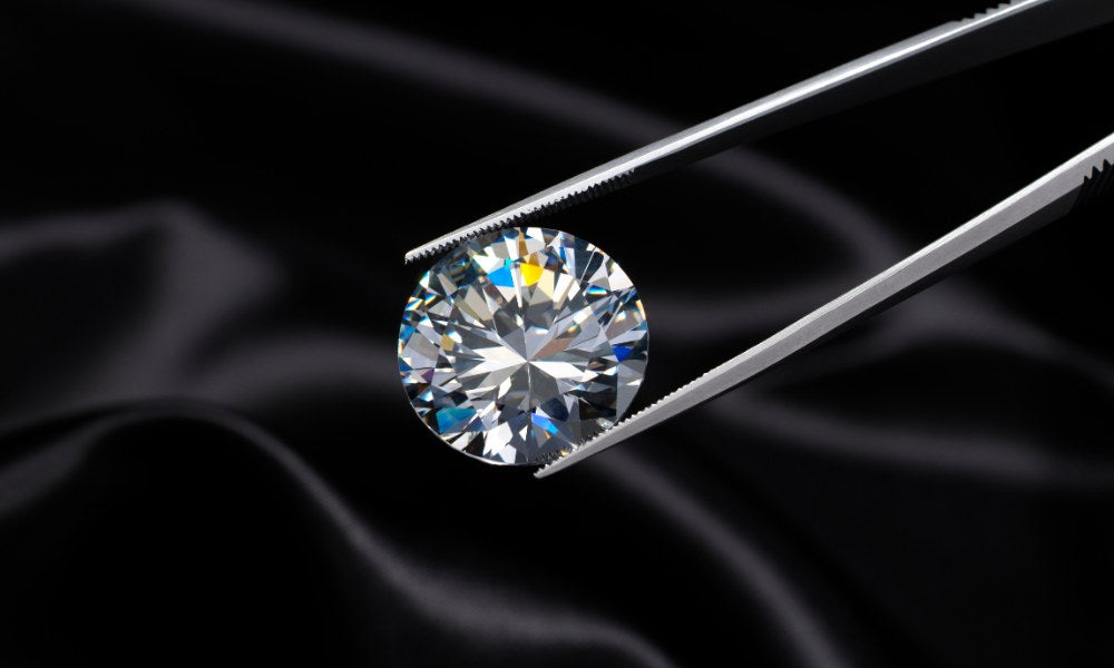 Labordiamant, der mit einer Pinzette gehalten wird, vor einem eleganten schwarzen Hintergrund, symbolisiert die Präzision und Qualität der nachhaltigen Schmuckherstellung bei VON RUWEN.